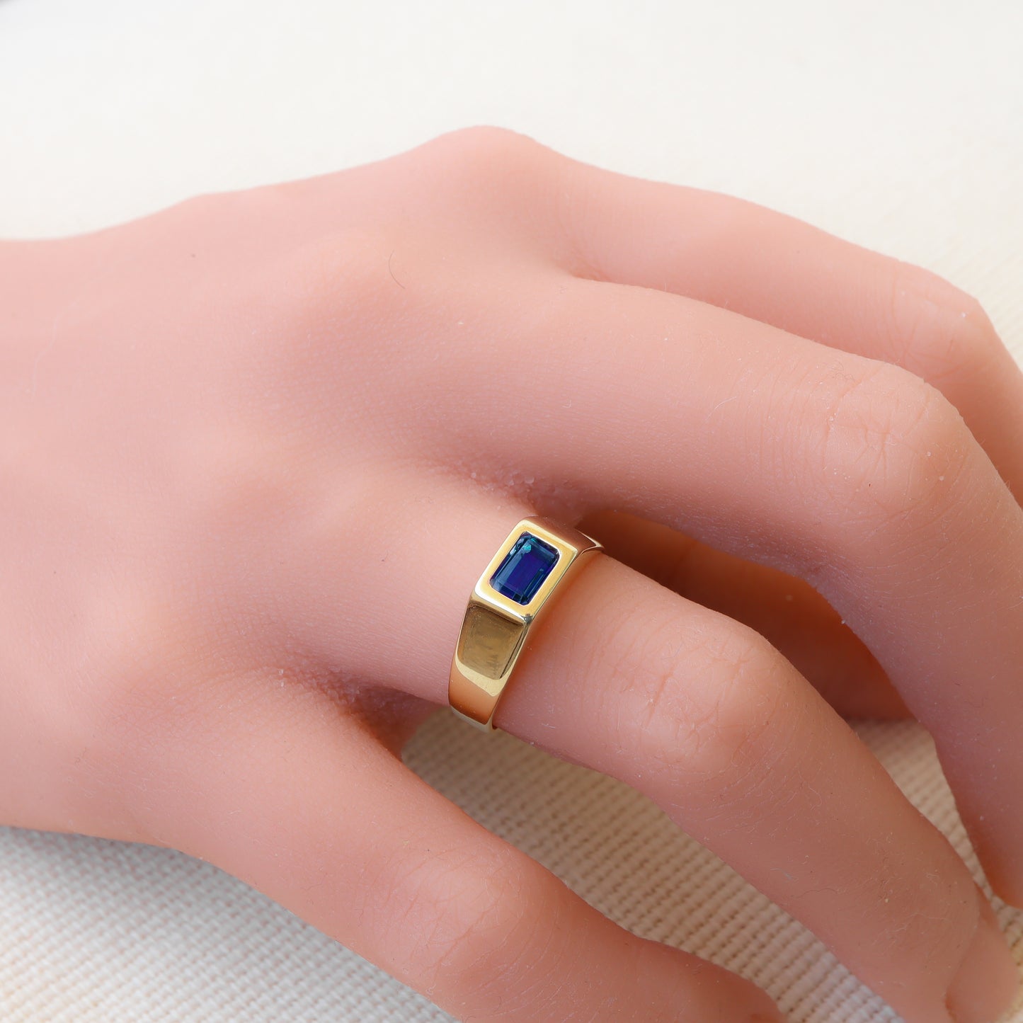 טבעת זהב צהוב בסגנון חותם קלאסי משובצת אבן ספיר כחול עדין.