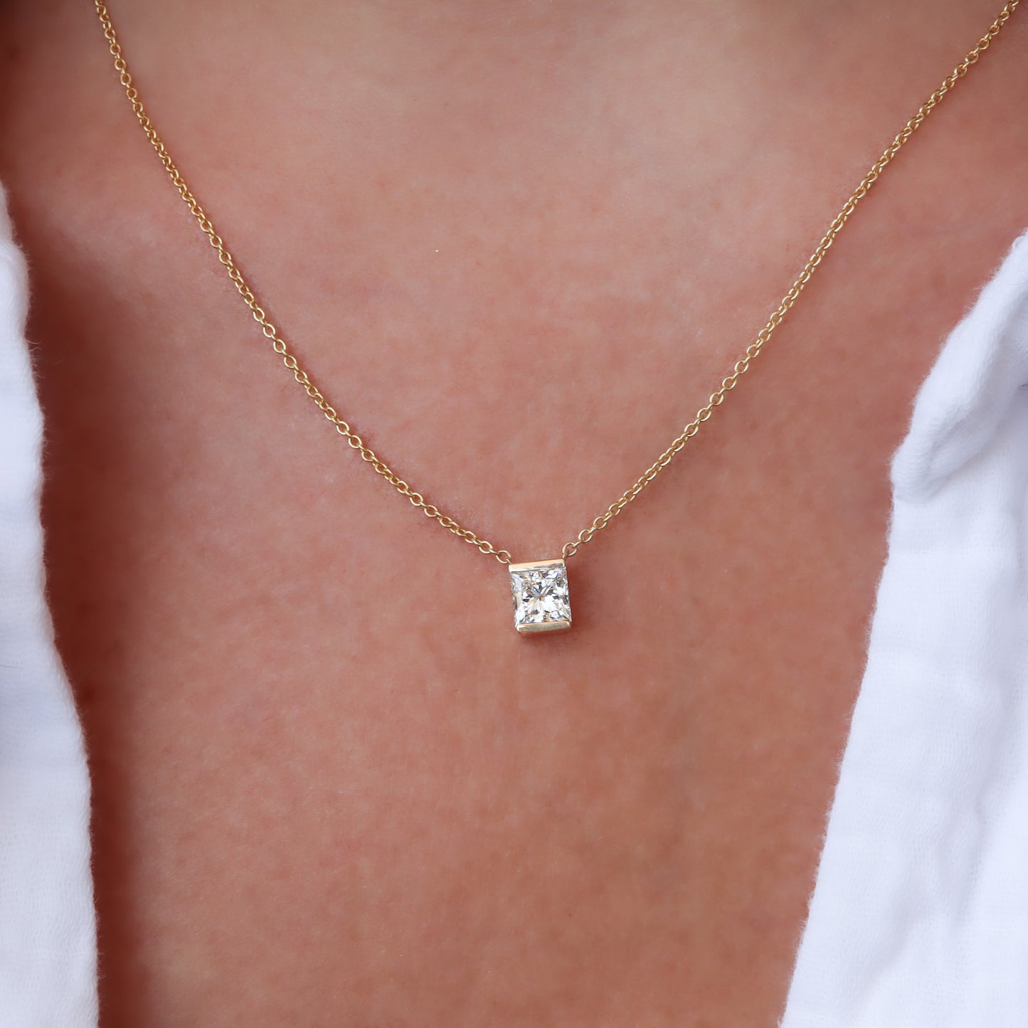 תקריב של שרשרת יהלום בחיתוך נסיכה על צווארה של אישה