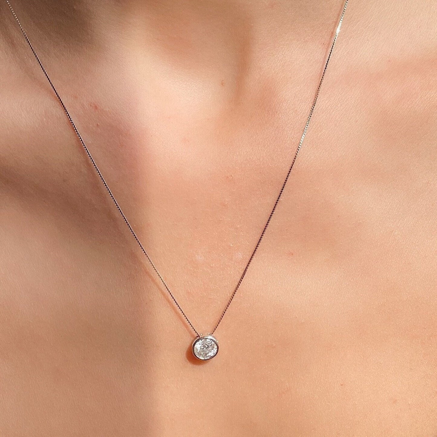 White Gold Floating Diamond Necklace with bezel setting, gracefully worn by a woman