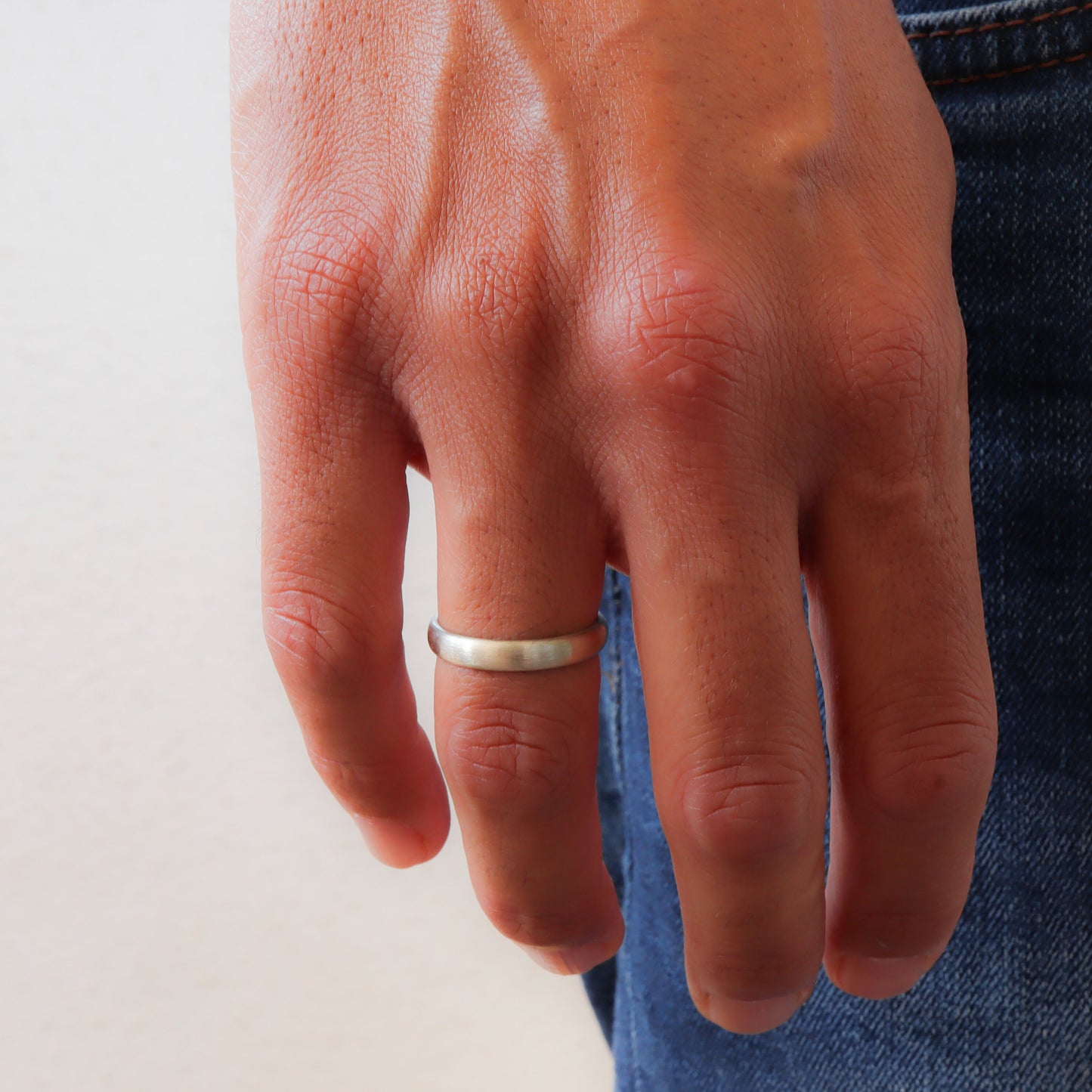 Elegant White Gold Men's Wedding Band on a groom's finger.