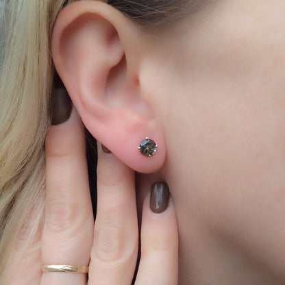 עגילי זהב צמודים עם אבני דובלט מיוחדות על האוזן, המדגישה את הפרופורציה والנוכחות של התכשיט.