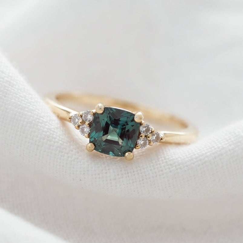A professional studio shot of the cushion cut sapphire ring focusing on the vibrant color gradients of the gemstone.
