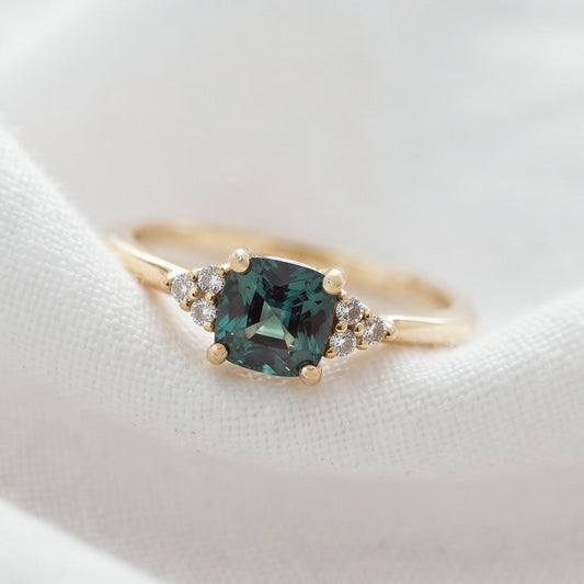 A professional studio shot of the cushion cut sapphire ring focusing on the vibrant color gradients of the gemstone.