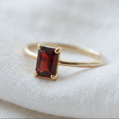 Solitaire ring in gold with a natural red garnet gemstone.