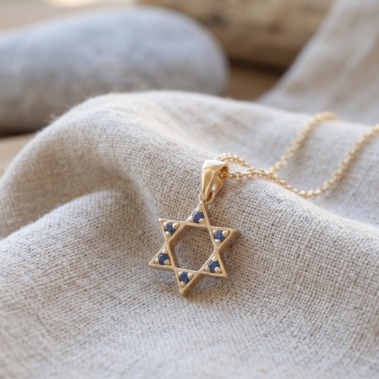 תליון מגן דוד בזהב צהוב עם אבני ספיר כחולות.