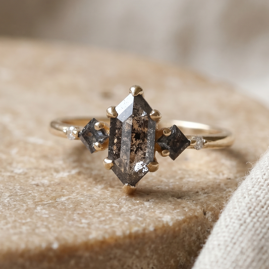 טבעת עם יהלומי מלח פלפל בחיתורך משושה מרובעים שני יהלומים שקופים בזהב צהוב.