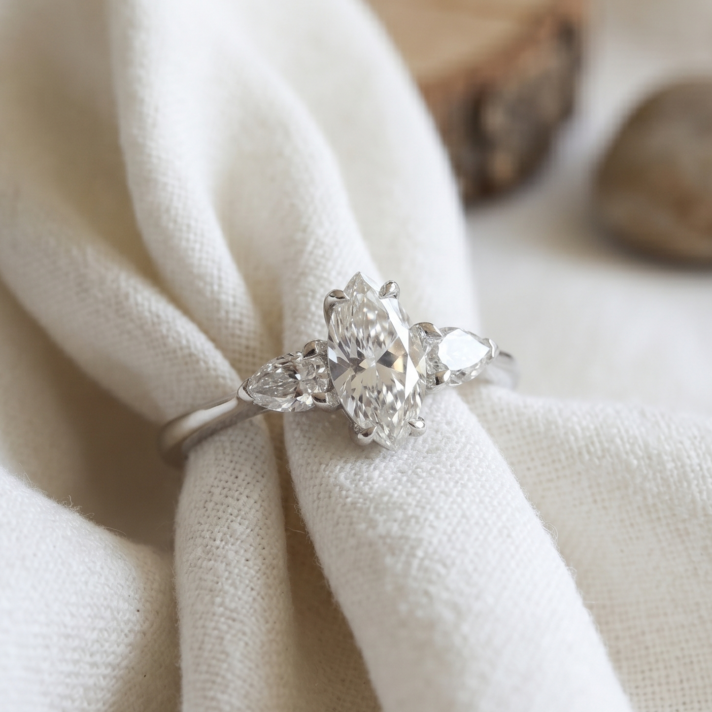 Three stone engagement ring featuring marquise and two pear diamond in white gold.