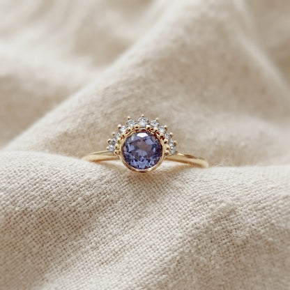 14k gold ring featuring a purple sapphire and diamond in a half halo setting design.