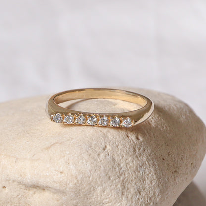 צילום מקרוב של הפרופיל הגיאומטרי השטוח של הטבעת המציג את איכות שיבוץ היהלומים בזהב.