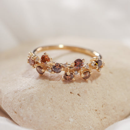 טבעת זהב קלאסטר משובצת שילוב של יהלומים חומים, כתומים ולבנים על אבן טבעית.