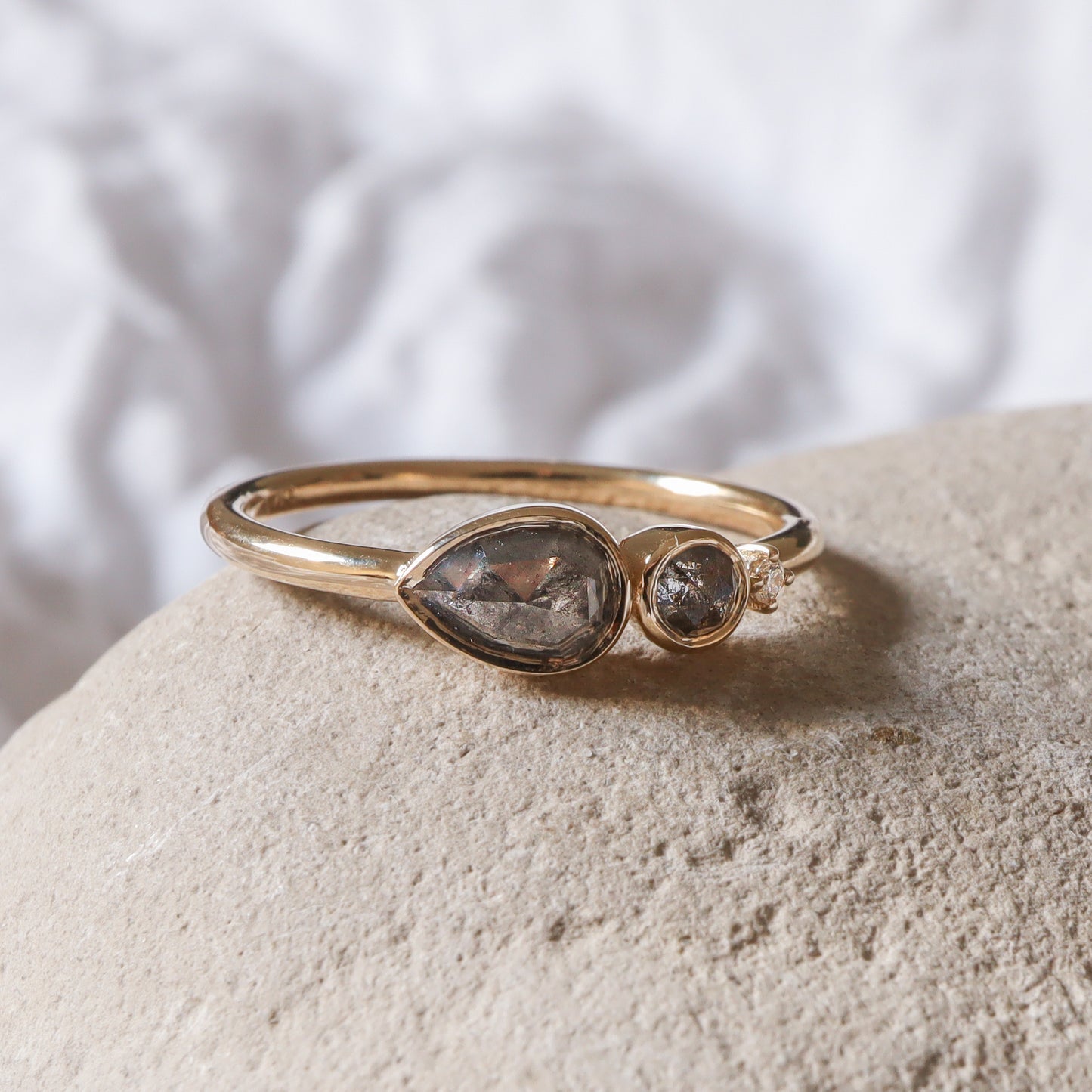 מבט מהצד על שיבוץ הכוס המגן של יהלומי המלח-פלפל, המדגיש את הגימור המבריק של הזהב.