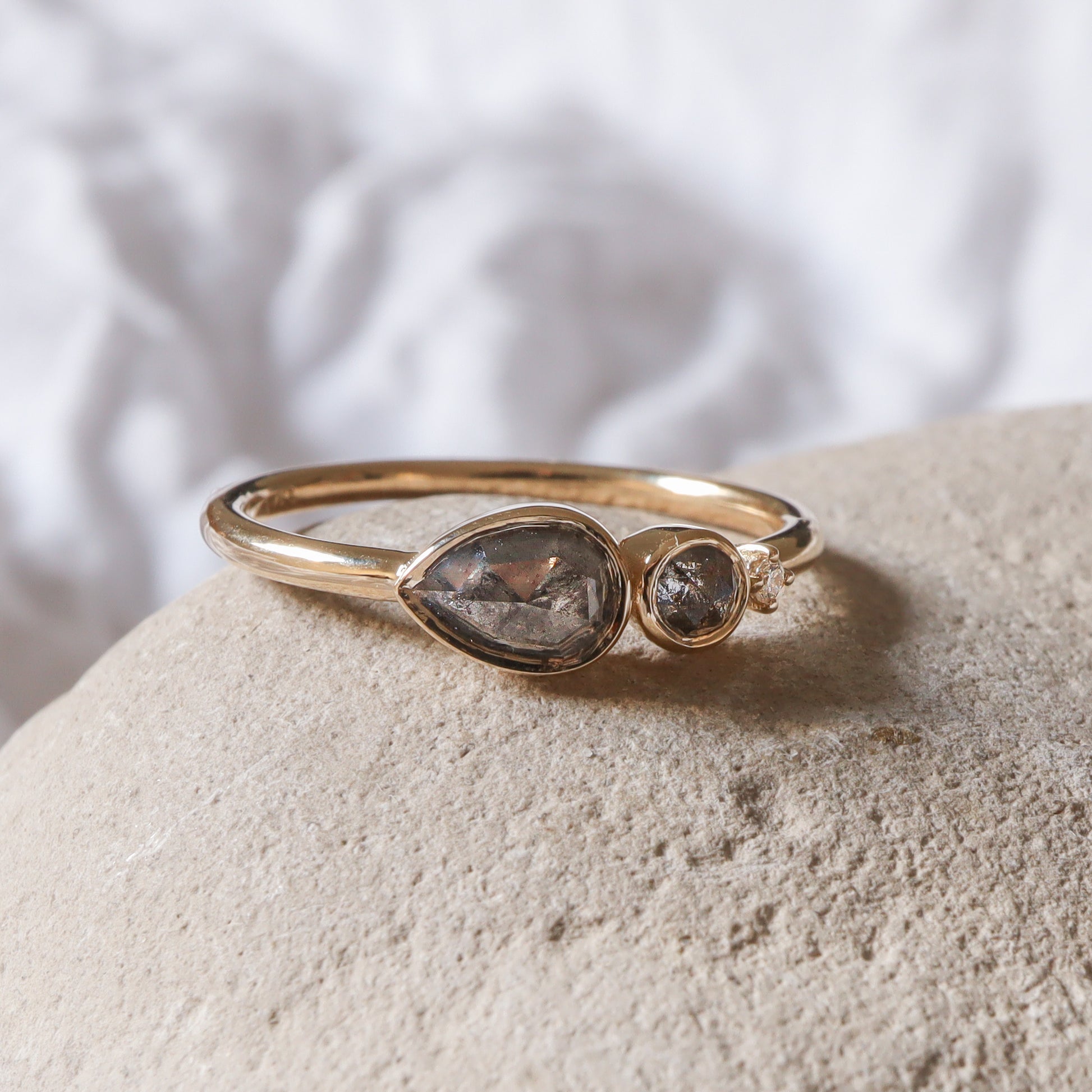 מבט מהצד על שיבוץ הכוס המגן של יהלומי המלח-פלפל, המדגיש את הגימור המבריק של הזהב.