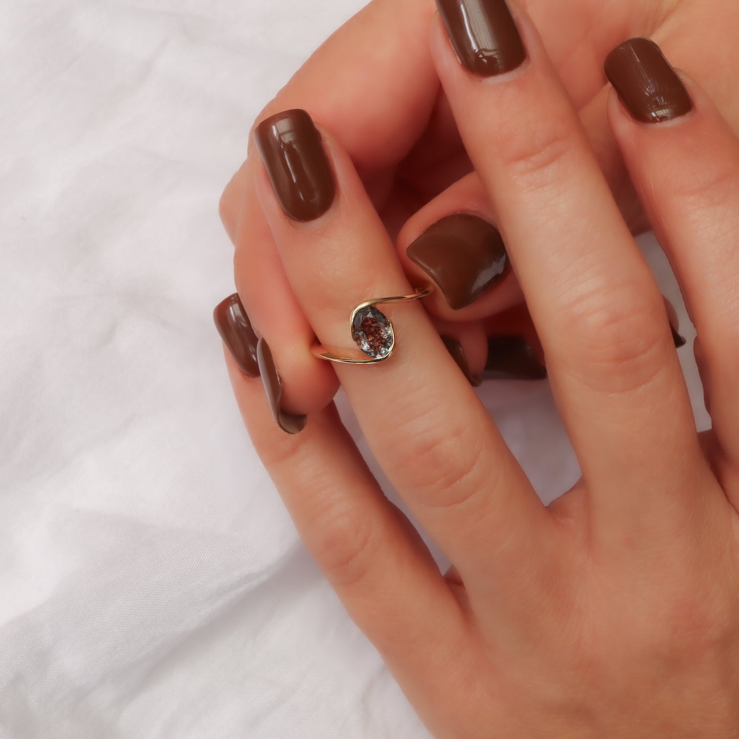 טבעת זהב 14 קראט עם אבן דובלט מרכזית בליפוף זהב אלגנטי על אצבע.