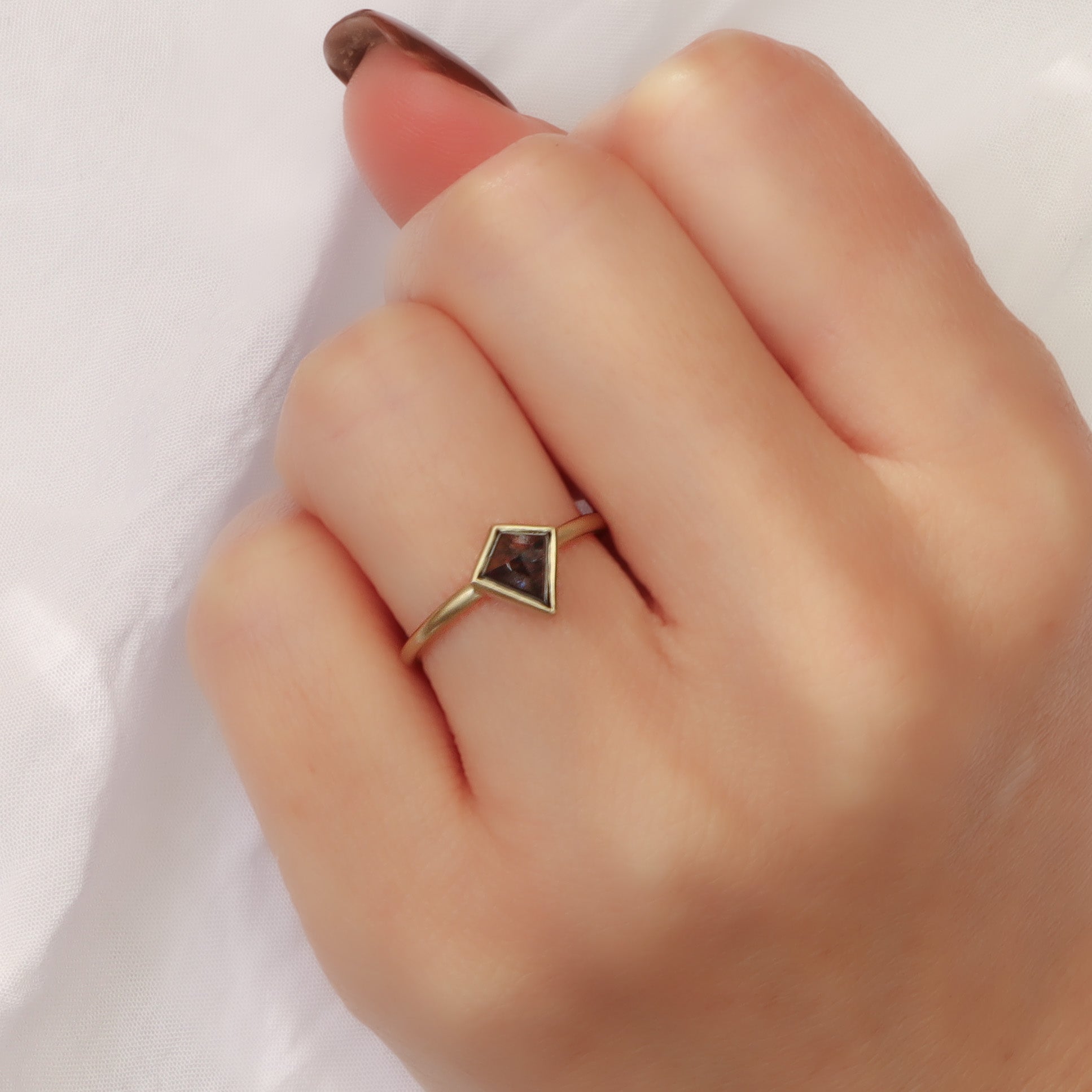 טבעת דלתון אפורה בגימור מט המציגה את הנוכחות הגיאומטרית והניגודיות בין הזהב ליהלום על היד.