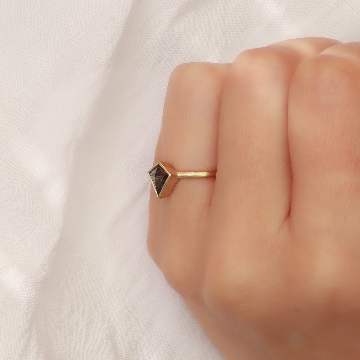 צילום מזווית המדגיש את גובה שיבוץ הכוס ואת הטקסטורה של הזהב בגימור המט סביב היהלום.