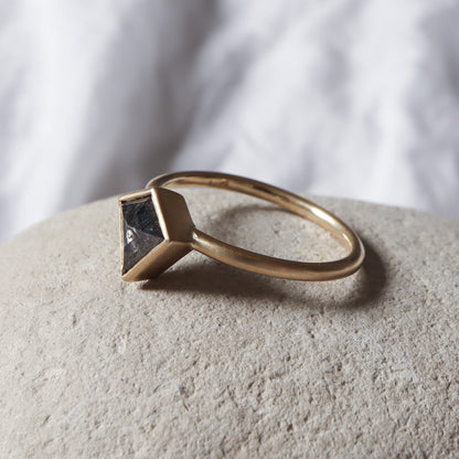 Profile angle of a salt pepper kite shape diamond set in a bezel ring with matte finish.