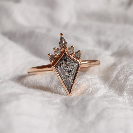 טבעת בזהב אדום משובצת יהחטן "מלח פלפל" בצורת דלתון בתוספת מסגרת של זהב ויהלומים בגוונים של אפור.