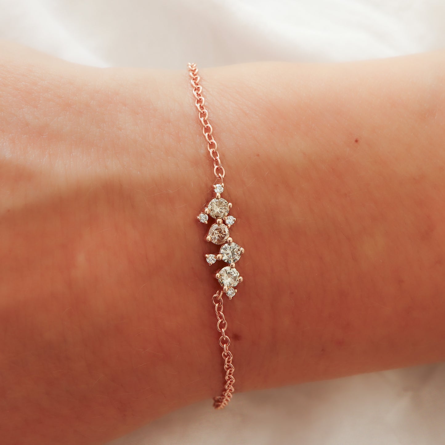 A close-up view of the rose gold bracelet on the wrist, highlighting the unique shade of the brownish-grey diamonds.