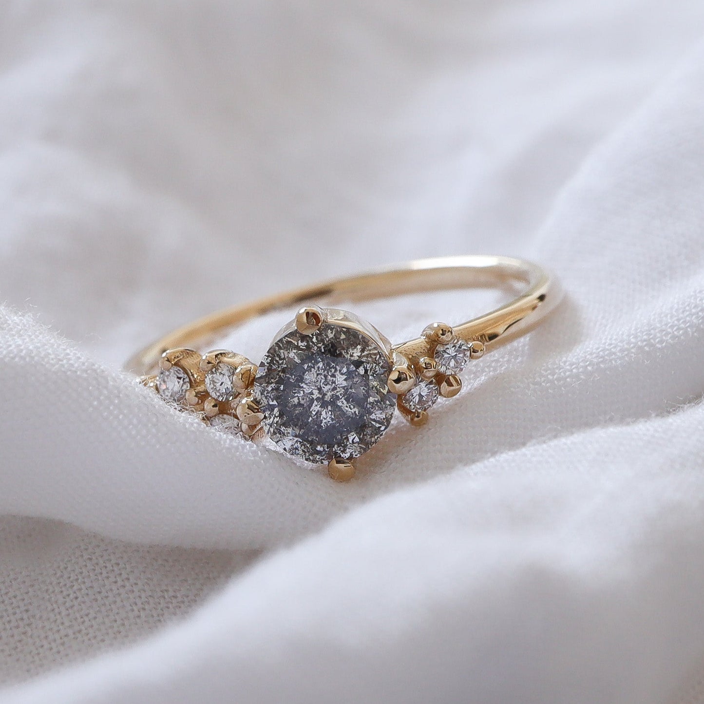 Gold cluster style ring featuring a salt and pepper diamonds accented with white clear diamonds.