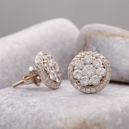 Halo Diamond cluster earrings in white gold, elegantly displayed on a grey stone.