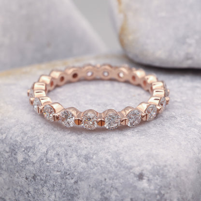 Top view of a beautiful rose gold eternity band featuring round diamonds.