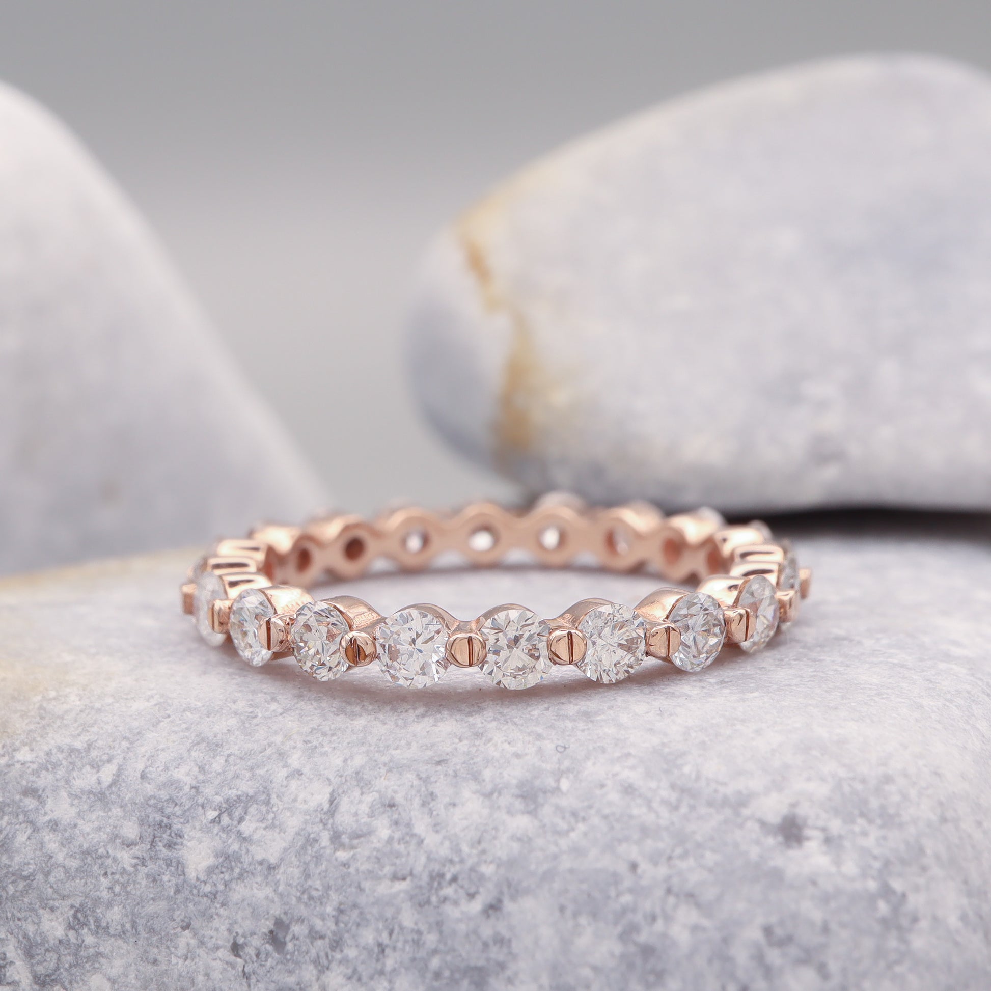 Dainty eternity bubble ring featuring round diamonds in rose gold.