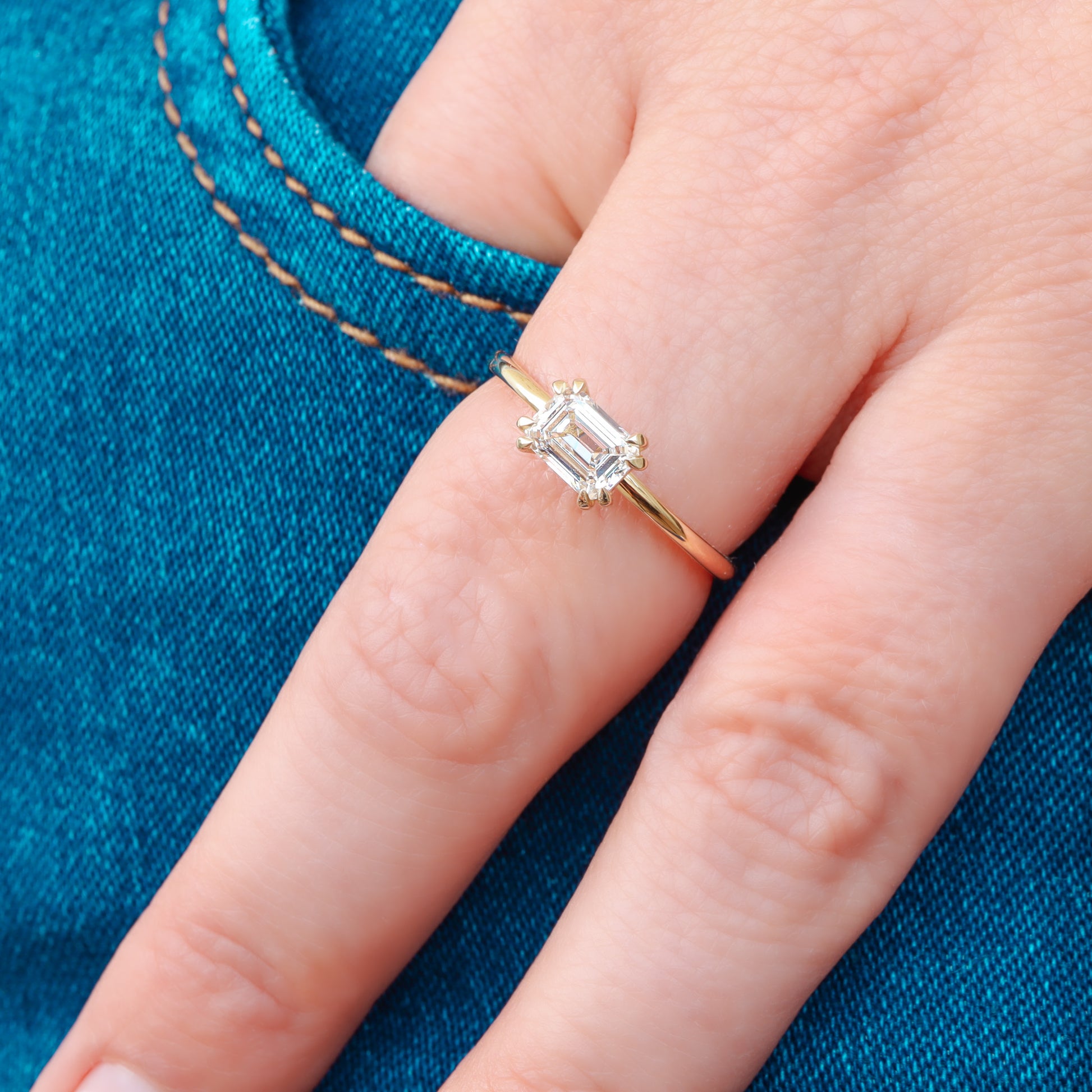 Chic and timeless Diamond Emerald Cut Engagement Ring adorning a woman's finger.