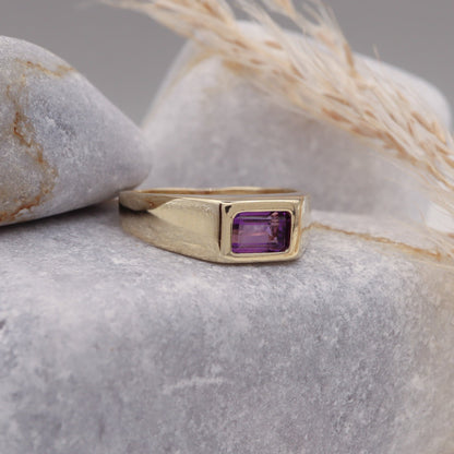 Profile view of the Natural Amethyst Square Signet Ring in Solid Gold displayed on a grey stone.