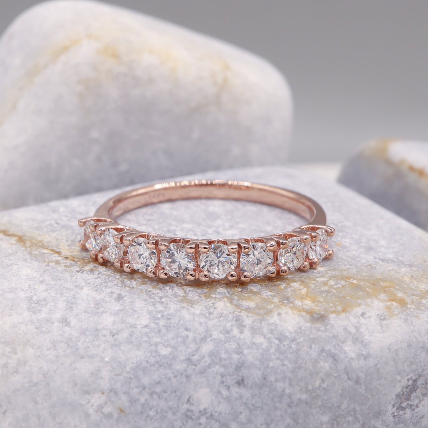 Stunning rose gold Delicate Diamond Half Eternity Ring, featured on a sophisticated grey stone.