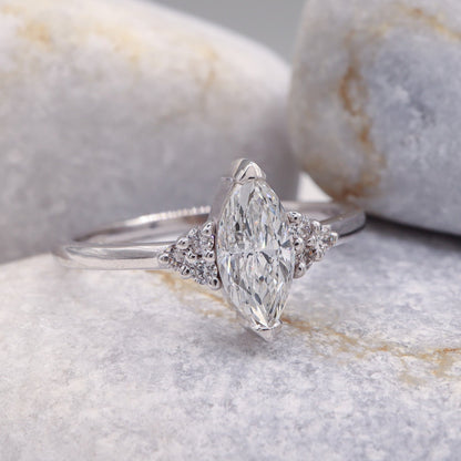 Elegant White Gold Marquise Diamond Ring featuring a contemporary tension setting, set against a backdrop of smooth grey stone.