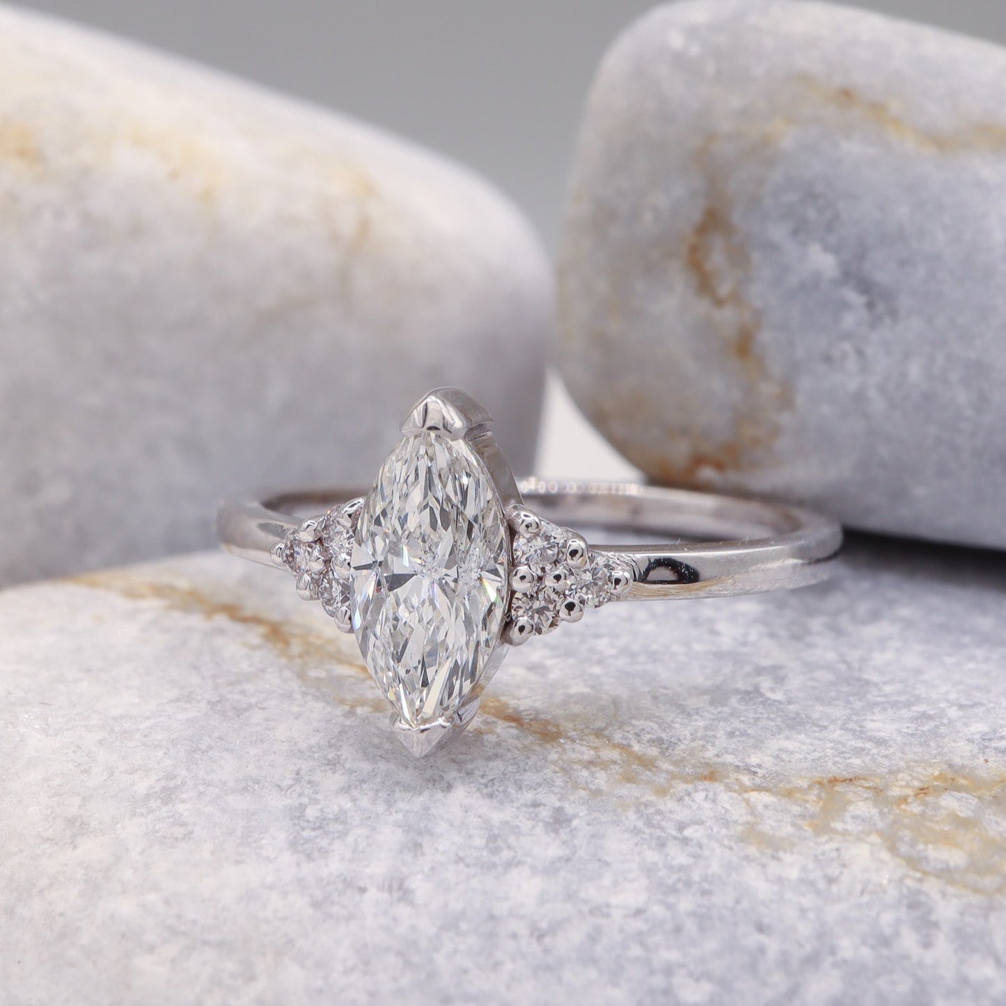 Chic and Timeless Marquise Diamond Ring with a White Gold Tension Setting, beautifully contrasted against a sophisticated grey stone surface.