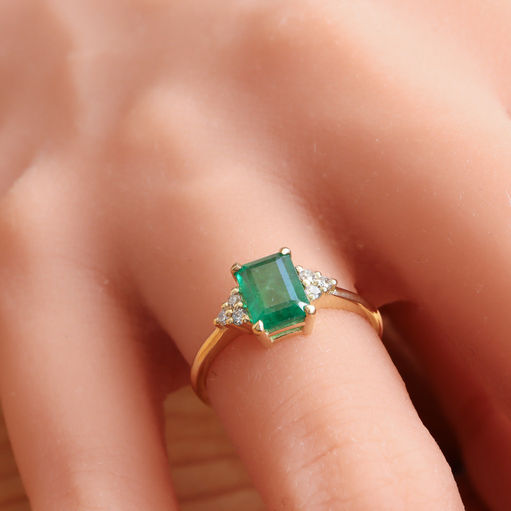 Green emerald gold ring accented with diamonds on each side.