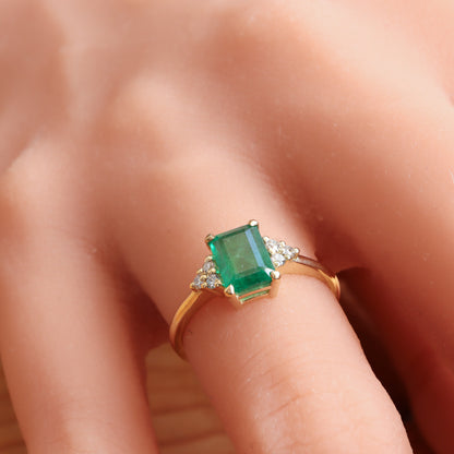 Green emerald gold ring accented with diamonds on each side.