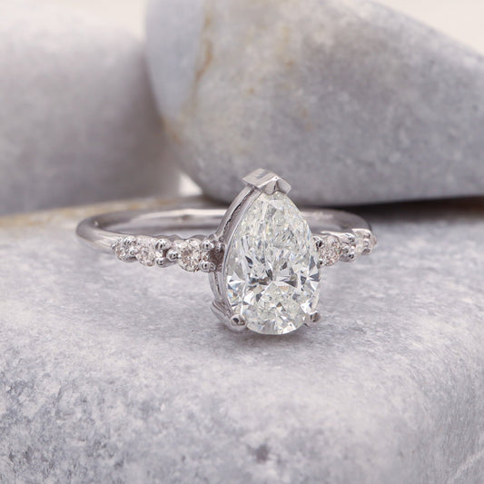 Pear Shape Diamond Ring in White Gold displayed on a grey stone background.