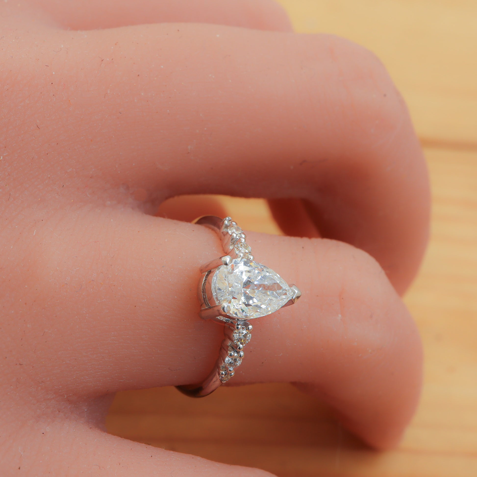 Dainty 18k white gold ring with pear-shaped diamond.