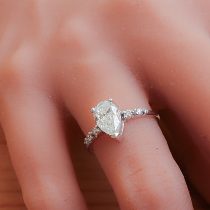 Elegant pear shape diamond engagement ring on a woman's hand.