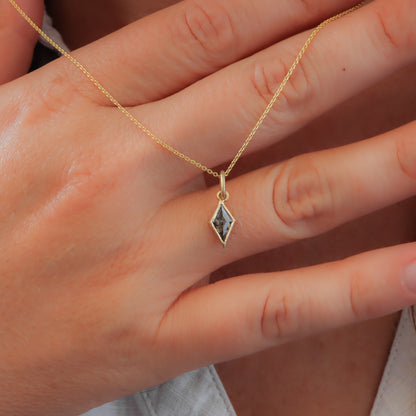 Salt and Pepper Diamond Necklace in Kite Shape with Bezel Setting, gracefully held on the back of a woman's hand