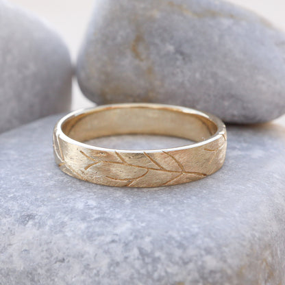 Engraved wedding band with tree branches texture.