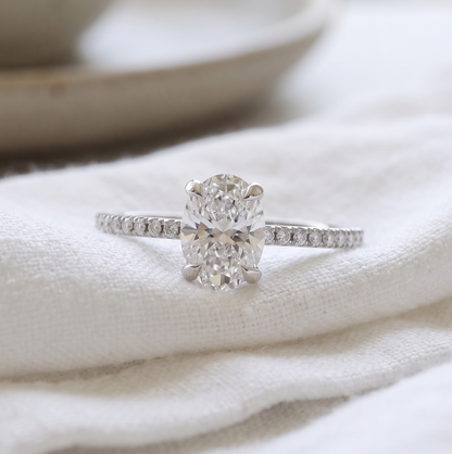 Oval engagement ring featuring oval diamond and diamonds on the side.