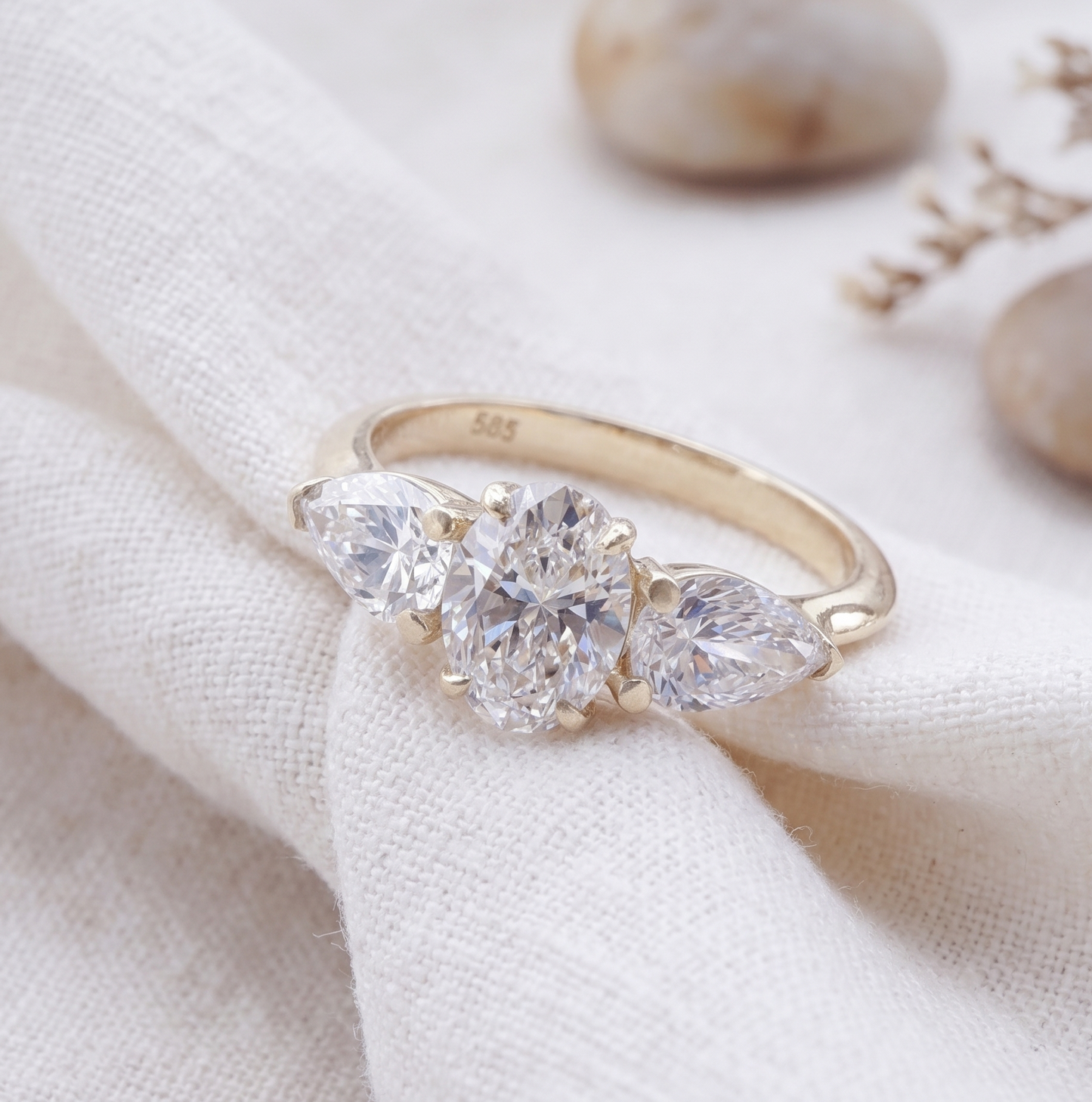 Three stone oval and pear diamonds in yellow gold.