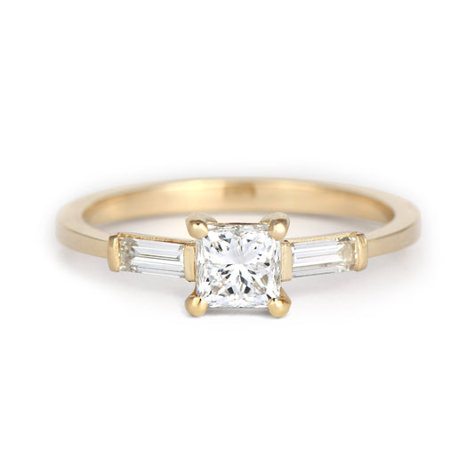 "Three stone Princess and Baguette cut Diamonds Ring in gold on a white background