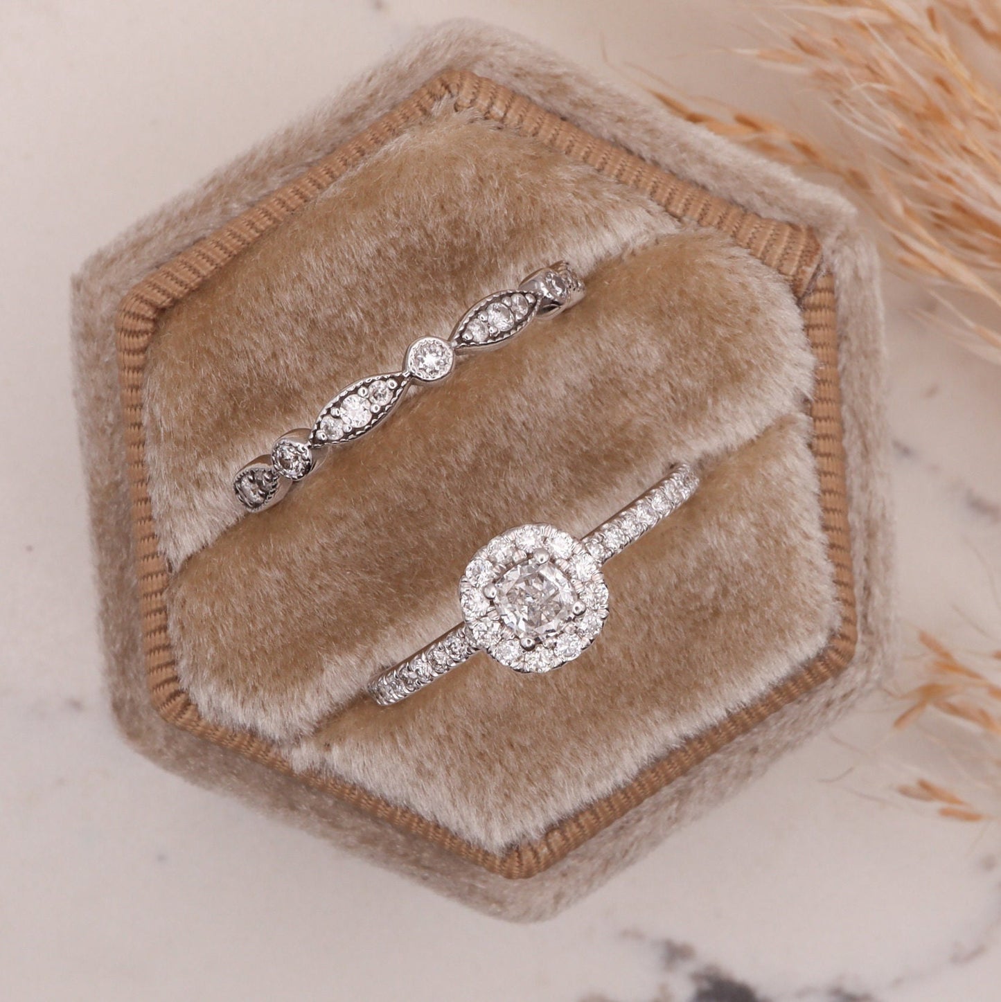 Cushion Cut Diamond Halo White Gold Ring, encircled by natural diamonds, showcased in a jewelry box beside a ring from the Dina Jewelry collection