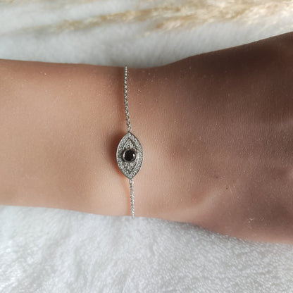 A woman showcasing the beauty of a white gold Evil Eye Bracelet with Black & White Diamonds on her wrist