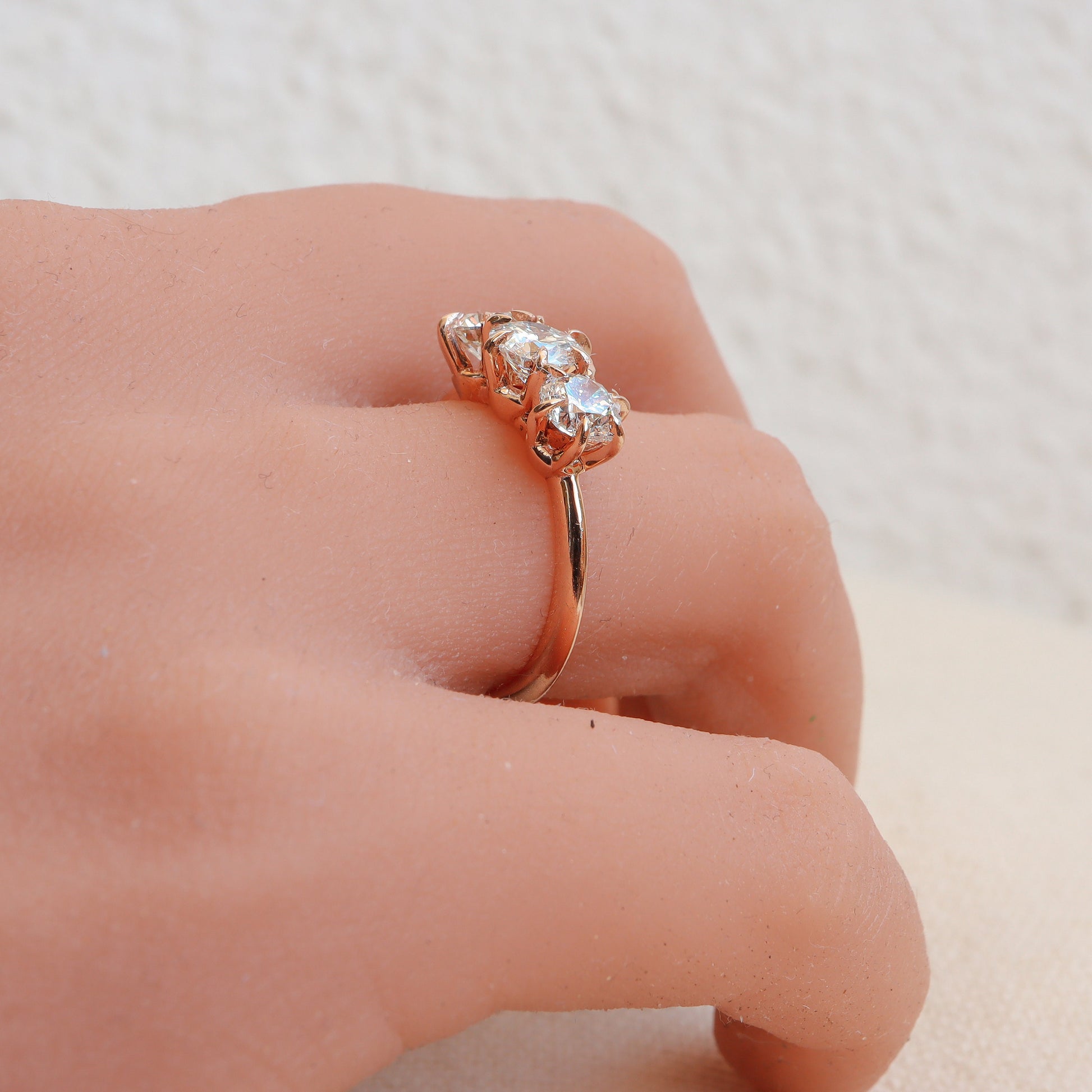 Rose gold three-diamond ring featuring a delicate 6-prong design, beautifully showcased on a woman's hand