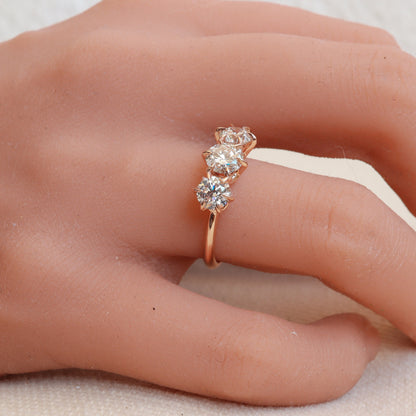 Three-diamond rose gold ring with a delicate 6-prong design, elegantly adorning a woman's hand