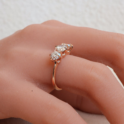 On a woman's hand, a stunning three-diamond rose gold ring with a delicate 6-prong design sparkles elegantly