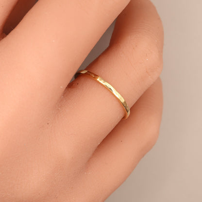 Hammered gold wedding ring elegantly worn on a woman's finger