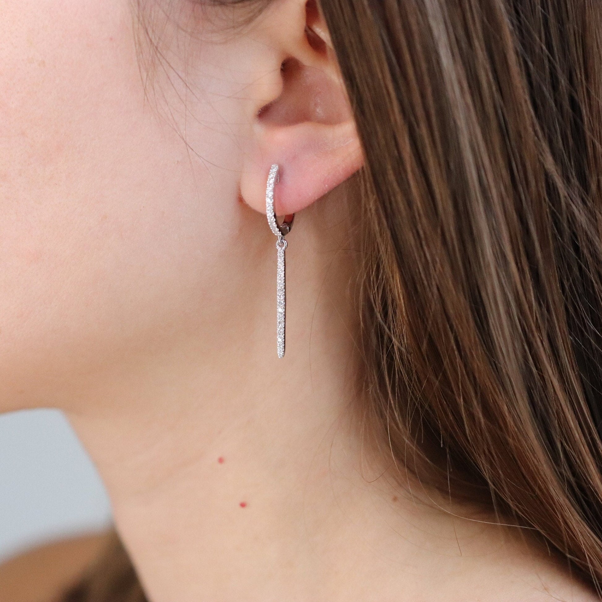 Woman wearing white gold hoop & drop diamond earring