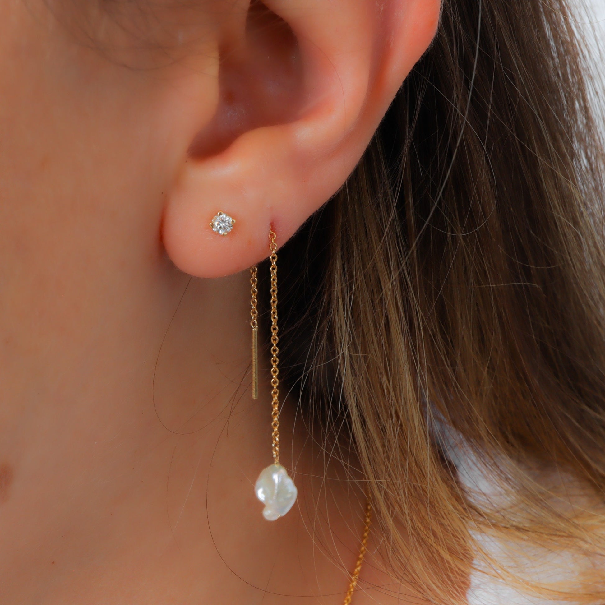 Uneven shaped pearl threader earring on a gold chain