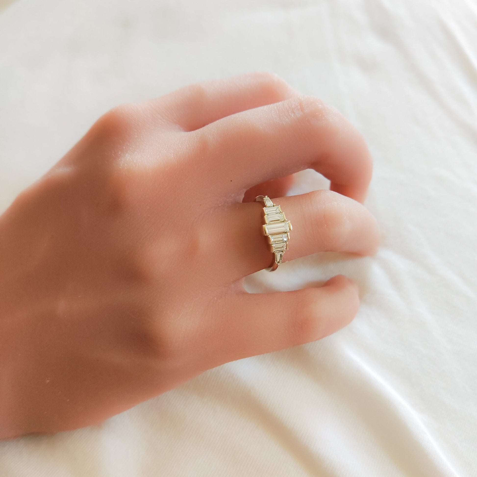 Diamond Baguette Gold Ring with Bezel-Set Vertical Step Design gracefully worn on a woman's hand.